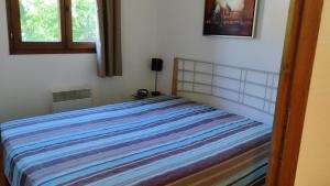 una camera da letto con un letto con una coperta a righe di Hameau 4 106 - SPA & PISCINE appartement 6 pers a Orelle