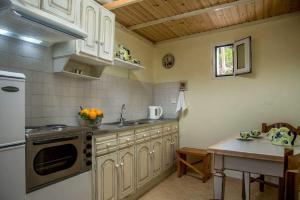 a kitchen with white cabinets and a sink and a table at Katerina's garden Apartment 2 - Tertsa Ierapetra in Térsa