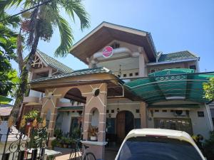 a house with a car parked in front of it at Flamboyan House in Padang