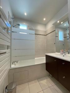 Un baño con bañera, lavabo y espejo. en Luxury Villa&6 pers&Parking free, en Magny-le-Hongre 51 fotos más