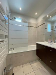 Un baño con bañera, lavabo y espejo. en Luxury Villa&6 pers&Parking free, en Magny-le-Hongre