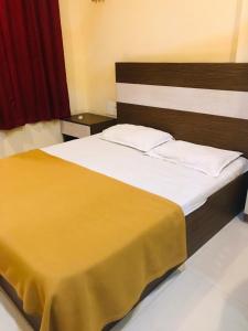 a bedroom with a large bed with a wooden headboard at Crown Palace Tourist Home in Ernakulam +8 photos