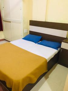 a bedroom with a large bed with blue pillows at Crown Palace Tourist Home in Ernakulam