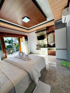 a bedroom with a large bed and a kitchen at Coral Bay Bungalows Amed Bali in Amed