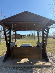 Un pabellón de madera en un campo con en Bungalov Terra, en Ljubuški 6 fotos más