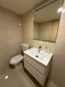 Un baño con un inodoro blanco y un lavabo. en Bungalov Terra, en Ljubuški