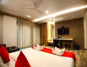 a bedroom with a large bed with red and white pillows at Royal Galaxy Hotel in Digha