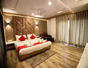 a bedroom with a large bed with red pillows at Royal Galaxy Hotel in Digha +57 photos