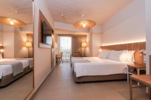 a hotel room with two beds and a television at BANCAL HOTEL and SPA in San Sebastián de la Gomera