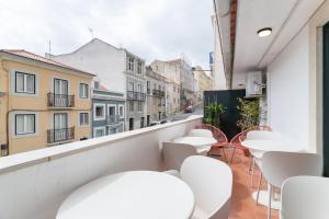 a balcony with tables and chairs and a view of a street at Lapa Diplomatic Suites & Flats by Feel Lisboa in Lisbon