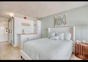 Un dormitorio con una cama blanca y una cocina. en BeachAHolic paradise, en Myrtle Beach 26 fotos más