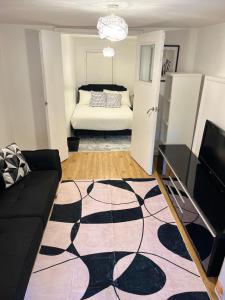 Forest HillにあるCozy Two Bedroom Flat 1 Minute from Forest Hill Train Stationのソファとベッドのあるリビングルーム