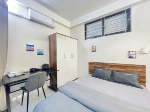 a bedroom with a bed and a desk and a bed and a chair at The Little'N Homestay Ha Noi 59 in Hanoi