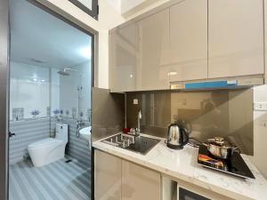 a kitchen with a sink and a bathroom with a toilet at The Little'N Homestay Ha Noi 59 in Hanoi
