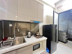 a kitchen with a sink and a refrigerator at The Little'N Homestay Ha Noi 59 in Hanoi +16 photos