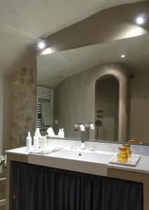 a bathroom with a sink and a large mirror at Les Vieux Murs in Montfort