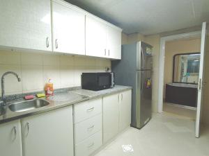 a kitchen with white cabinets and a stainless steel refrigerator at One Master Bedroom Fully Furnished in Sharjah +12 photos