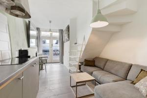 Una sala de estar con un sofá y una cocina. en Beautiful 'tiny house' in Utrecht City Center, en Utrecht