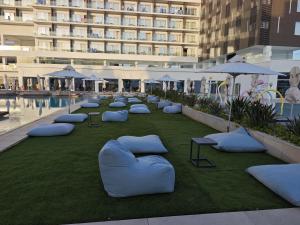 a row of pillows on a lawn in front of a building at Chrysomare Beach Hotel & Resort in Ayia Napa