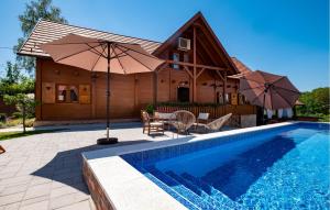 une maison avec une piscine et une maison avec un parasol dans l'établissement Four-Bedroom Holiday Home In Velika Buna, à Velika Buna