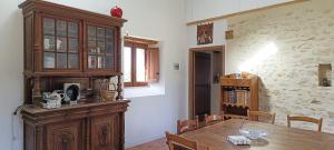 a dining room with a table and a wooden cabinet at L'entre-deux-pommes in Lézigné