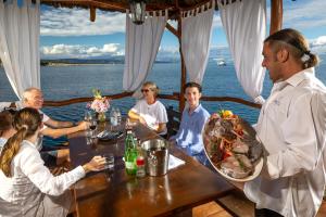 a group of people sitting around a table on a boat at Apartments Rubin in Zastražišće