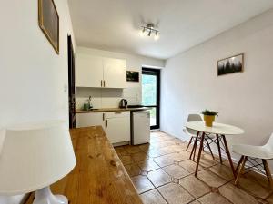 eine Küche mit weißen Schränken und einem Tisch und Stühlen in der Unterkunft Studio Żubrowe II in Przymorze