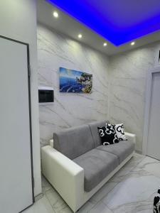 a living room with a couch and a blue ceiling at Testa House 2 0 in Catania