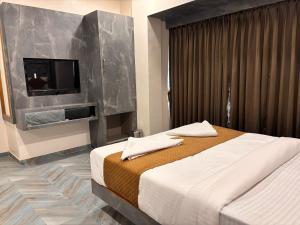 a bedroom with a bed and a flat screen tv at hotel Arts palace in Mumbai