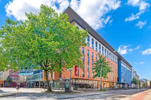 a large brick building on a street with a tree at ibis Hotel Hamburg St. Pauli Messe in Hamburg