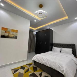 a bedroom with a large bed with a ceiling at Tarom Luxury Apartment in Port Harcourt +5 photos
