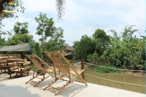 a group of wooden chairs sitting on a patio at Ann Homestay in Can Tho