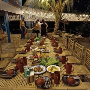 a long wooden table with plates of food on it at Ann Homestay in Can Tho