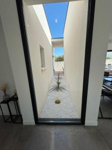 a room with a window with a plant in the middle at Villa Noam Haut Standing 220m2 in Beauvoisin