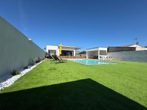 a house with a lawn and a swimming pool at Villa Noam Haut Standing 220m2 in Beauvoisin
