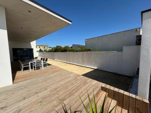 a deck with a table and chairs on a house at Villa Noam Haut Standing 220m2 in Beauvoisin +17 photos