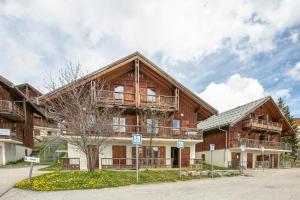 ein großes Holzgebäude mit Balkonen darauf in der Unterkunft NOEMA - vue montagne in La Toussuire