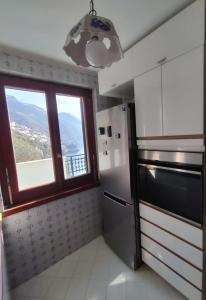 a kitchen with a window and a stainless steel refrigerator at Casa Il Panorama in Praiano
