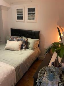 ein Schlafzimmer mit einem Bett und einem Tisch mit einer Pflanze in der Unterkunft New 1 Bed Apartment 12 mins to Central London and Gatwick Airport in Croydon