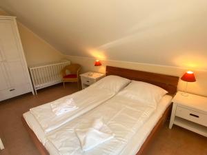 a large white bed in a room with two tables at Ferienhaus Mein Panama in Zingst +11 photos