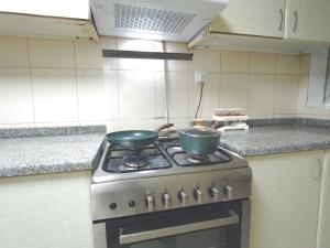 a kitchen with a stove with two pots on it at One Bedroom Twin Bed Fully Furnished in Sharjah
