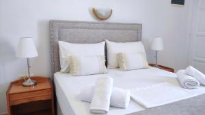 a white bed with pillows and towels on it at Astrofegia Rooms and Apartments in Kamares