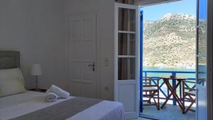 a bedroom with a bed and a view of the ocean at Astrofegia Rooms and Apartments in Kamares