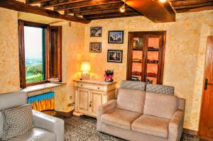 a living room with a couch and a chair and a window at Casale Colle Belvedere in Lucca