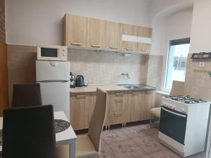 a small kitchen with a white refrigerator and a table at Csobánc apartman in Tapolca