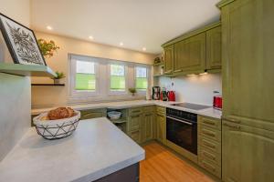 cocina con armarios verdes y encimera en Strandhaus Möwe, en Zempin 9 fotos más
