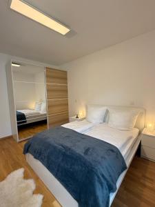 ein Schlafzimmer mit einem großen Bett und einem Spiegel in der Unterkunft ElbeCity Apartment in Dresden