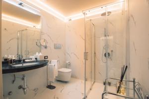 a bathroom with a shower and a toilet and a sink at Hotel Villa Maria Au Lac - Estella Hotels Italia in Toscolano Maderno +121 photos