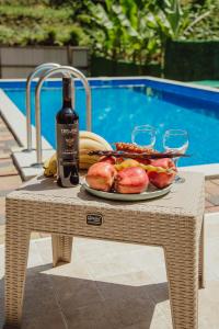 Una mesa con un plato de comida y una botella de vino. en Villa Lile, en Batumi