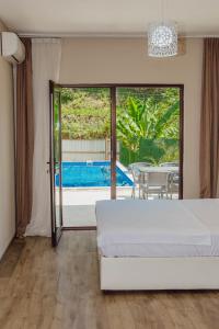 Un dormitorio con una cama y vistas a una piscina. en Villa Lile, en Batumi